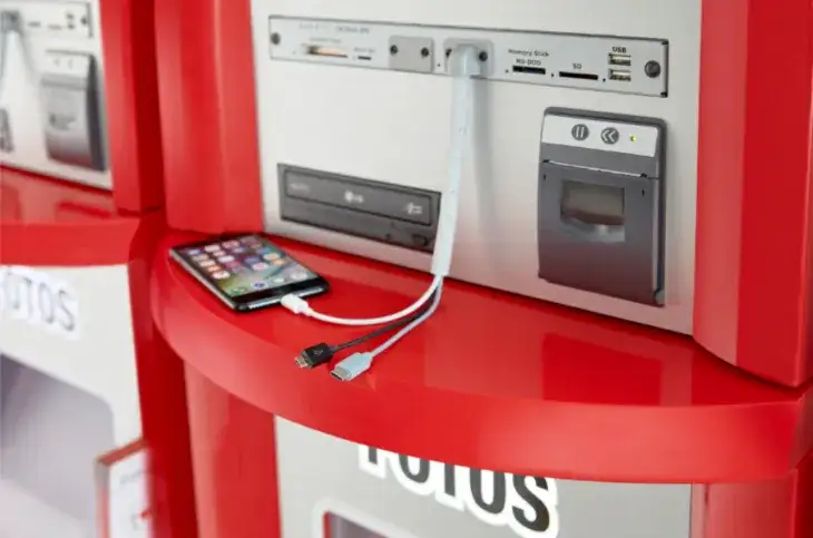 osoba wywołująca zdjęcia z telefonu w fotolabie, kiosk fotograficzny